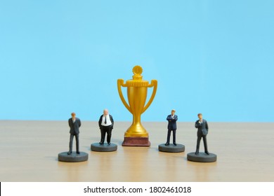 Miniature Business Concept - Businessman Lineup Base On Rank With Golden Trophy In The Middle