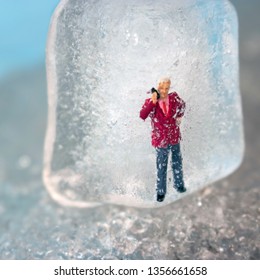 Miniature Business Man Frozen In Time Talking On His Outdated Cell Phone. Ice Man Trapped By Modern Technology. Boss Or Employee Is Left Out In The Cold. Problems Working In Tech. Man Chilling Out.