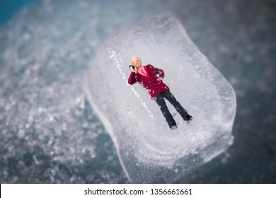 Miniature Business Man Frozen In Time Talking On His Outdated Cell Phone. Ice Man Trapped By Modern Technology. Boss Or Employee Is Left Out In The Cold. Problems Working In Tech. Man Chilling Out.