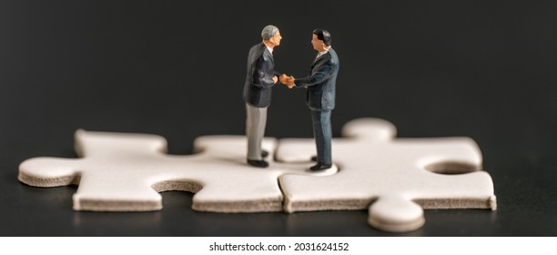 Miniature business man shake hand partner client customers on white Jigsaw Puzzle with success dealing business using as contract commitment agreement investment and partnership business development - Powered by Shutterstock