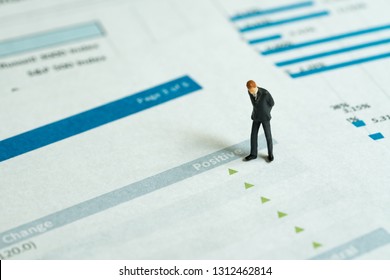 Miniature Businessman Looking At Green Pointing Up Arrows Of Investment Report, Stock Price Go Up, Positive Sentiment, Good Sign Of Situations In Which Some Financial Assets Gain Value.