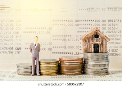 Miniature businessman stand on the stack of coins on book bank background with light. Financial concept. - Shutterstock ID 580692307