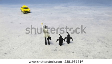 Miniature Businessman and Two Penguins Waving for Taxi-Cab.