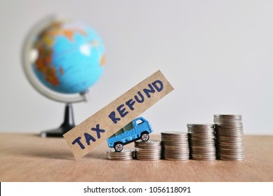 Miniature Car Carry Paper With “tax Refund” Word And Drives On Roll Increasing Ladder Of Coin Money On Wood Table In Blur World Globe On White Background