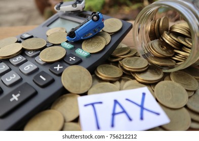 Miniature Car Falls With Wheels Off On Calculator And Coins Money Pouring From Glass Bottle With “tax” Word Written On White Paper