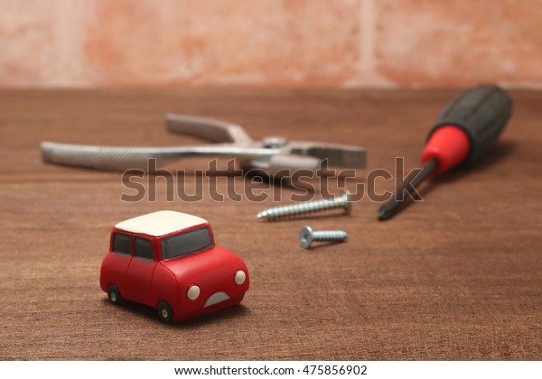 Miniature car and maintenance tools on wood.\
\
Concept of car\
maintenance.