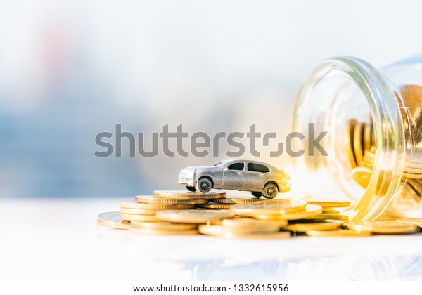 Miniature car model and Financial statement\
with coins. Finance and car loan, saving money for a car or\
material design\
concepts.