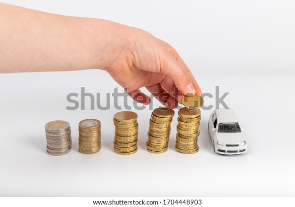 Miniature car model and Financial statement\
with coins. Finance and car loan, saving money for a car or\
material design\
concepts.