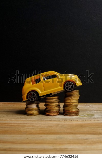 Miniature car on coin stack. Auto\
transportation\
conceptual.