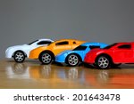 miniature colorful cars standing in line showroom sale concept. Different colored cars - blue, yellow, orange, white and red color cars standing next to each other - car agent sale concept