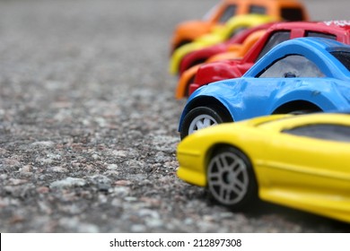 miniature colorful cars standing in line on road sale concept. Different colored cars - blue, yellow, orange, white and red color cars standing next  - car agent sale concept