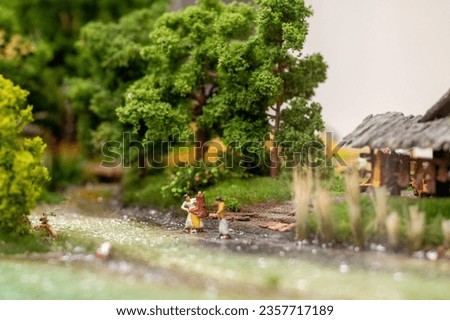 Miniature diorama at Miniatur Wunderland in Hamburg, Germany, depicting a historical scene with people going about their daily lives in the Neolithic Age, washing clothes in a river outside a smallhut
