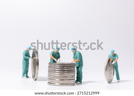 Miniature doctors examining a stack of coins on white background, healthcare finance and medical cost concept with teamwork and planning.