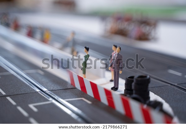 Miniature doll in race track,\
Miniature people watching racing cars in the field. Selective\
Focus.