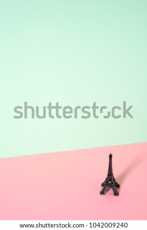 a miniature of the miniature of Eiffel Tower in a colorful pink and green background, with a large blank space on top