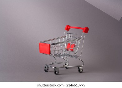 Miniature empty pushcart, customers truck, shopping trolley in mall, supermarket. Consumtion, commerce, trade, shopaholism concept. Copy space.
