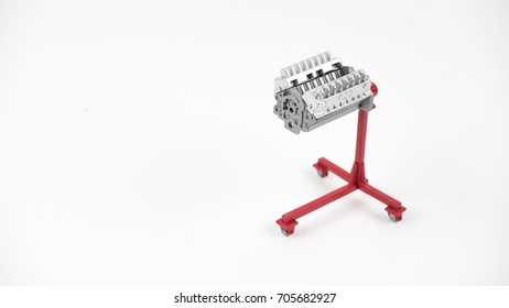 Miniature of an engine block with stand. Concept of clean auto part. Isolated on white background. Slightly de-focused and close-up shot. Copy space.