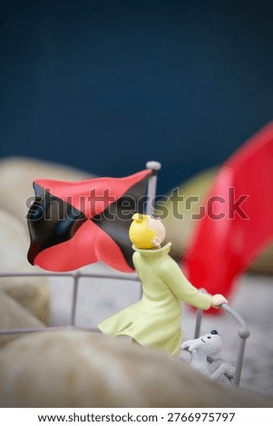 Miniature explorer character looking at a rocket in the distance, concept of ambition, exploration and future goals. Creative conceptual image with shallow depth of field.