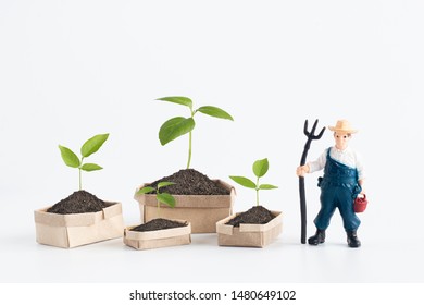 Miniature Farmer figure model planting and take care of the tree isolated on white background, environment and agriculture concept