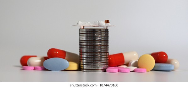 A Miniature Female Patient Lying On A Bed On A Coins. The Concept Of Economic Hardship On Rising Treatment Costs.