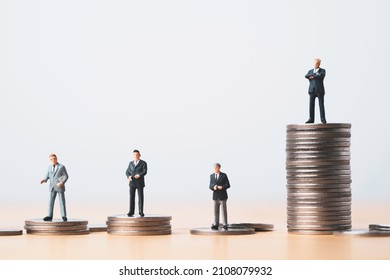 Miniature figure of four businessmen standing to different high and low coins stacking for position and successful business investment income concept.