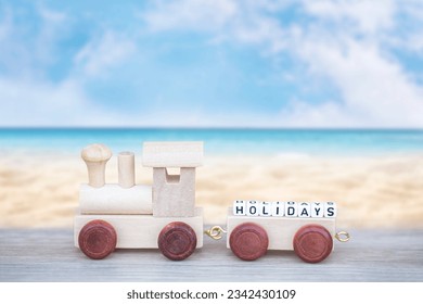 Miniature figure wood train toy carry block Holiday text over summer beach blue sea. - Powered by Shutterstock