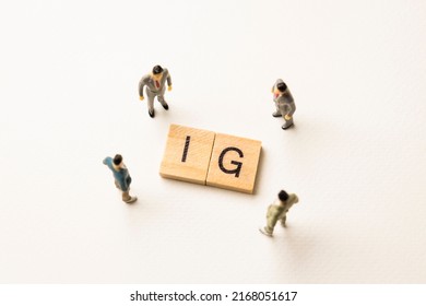 Miniature figures businessman : meeting on ig word by wooden block words on white paper background, ig is abbreviation from instagram in concept of social media, business and corporation.