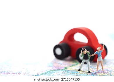 Miniature figures explore a map while a toy car is nearby