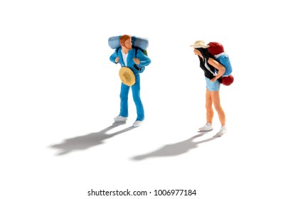 Miniature figures of two travellers or backpackers on a white background with shadows standing looking at each other in a concept of vacations, travel and tourism - Powered by Shutterstock