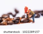 Miniature figures working on coffee macro photography on white background