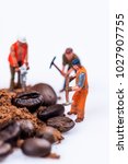 Miniature figures working on coffee macro photography on white background