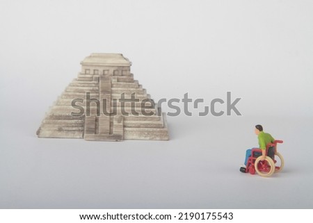 miniature figurine of a disabled man on a wheelchair with a Mayan pyramid 