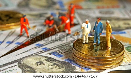 Miniature figurine : Financial Business Group standing on bitcoin and Workers are digging dollar Creating wealth for the capitalists. Digital Money and Bitcoin, Success, dealing and partner concept.