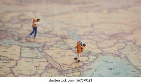 Miniature figurine of  friends couple young traveler walking  on big map   - Powered by Shutterstock