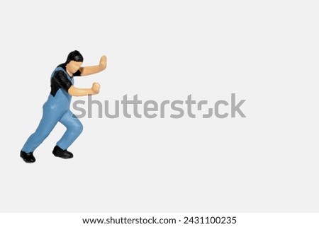 miniature figurine of a worker pushing something isolated on white background