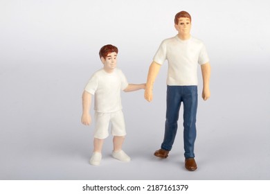 Miniature Figurines Of A Child With His Father 