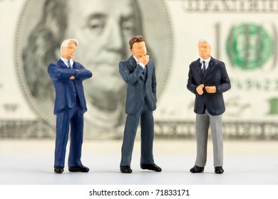 Miniature Figurines Of Successful Business Team With $100 Banknote On Background