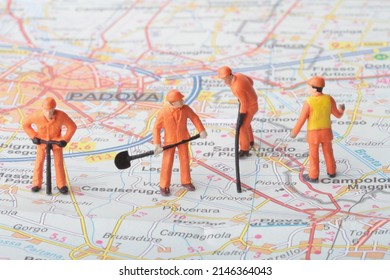 Miniature Figurines Of A Team Of Men At Work On A Street Directory Map