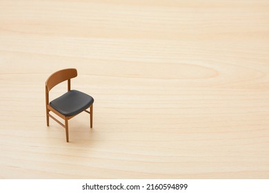 Miniature furniture toy isolated on wood background. Minimalist style. Miniature chair. Miniature toy. Scandinavian style. Nordic style. Simplicity. Mid century furniture.