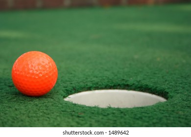 A Miniature Golf Ball Near The Hole