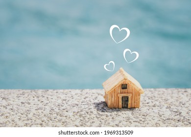 miniature house and  heart shape on concrete floor with blurred blue background, copy space, home sweet home , valentine, happy family concept