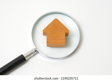 The miniature house and  a magnifying glass in white background