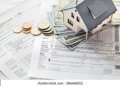 Miniature House With Money On Tax Papers.