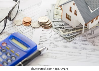 Miniature House With Money And Tax Papers.