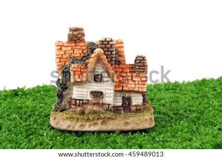 miniature house on green grass isolated on white