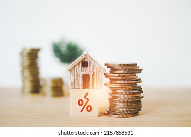 miniature house on wooden cube block with red increasing percent and stack of coins - Shutterstock ID 2157868531