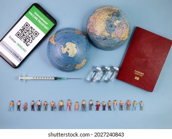 Miniature Human Figure Figurine Male Female Doll Row Vaccine Passport Digital Paper Book Bottle Medical Injection Syringe Needle World Map Globe Border Copy Text Sign Space On Blue Paper Background