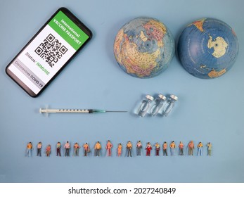 Miniature Human Figure Figurine Male Female Doll Row Vaccine Passport Digital Paper Book Bottle Medical Injection Syringe Needle World Map Globe Border Copy Text Sign Space On Blue Paper Background