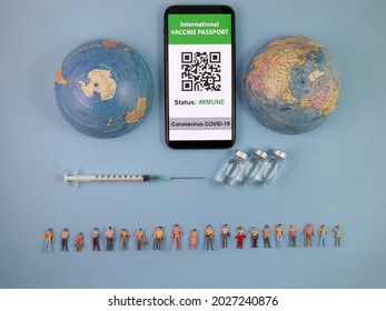 Miniature Human Figure Figurine Male Female Doll Row Vaccine Passport Digital Paper Book Bottle Medical Injection Syringe Needle World Map Globe Border Copy Text Sign Space On Blue Paper Background