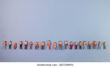 Miniature Human Figure Figurine Male Female Doll Row Line Border Copy Text Sign Space On Blue Paper Background